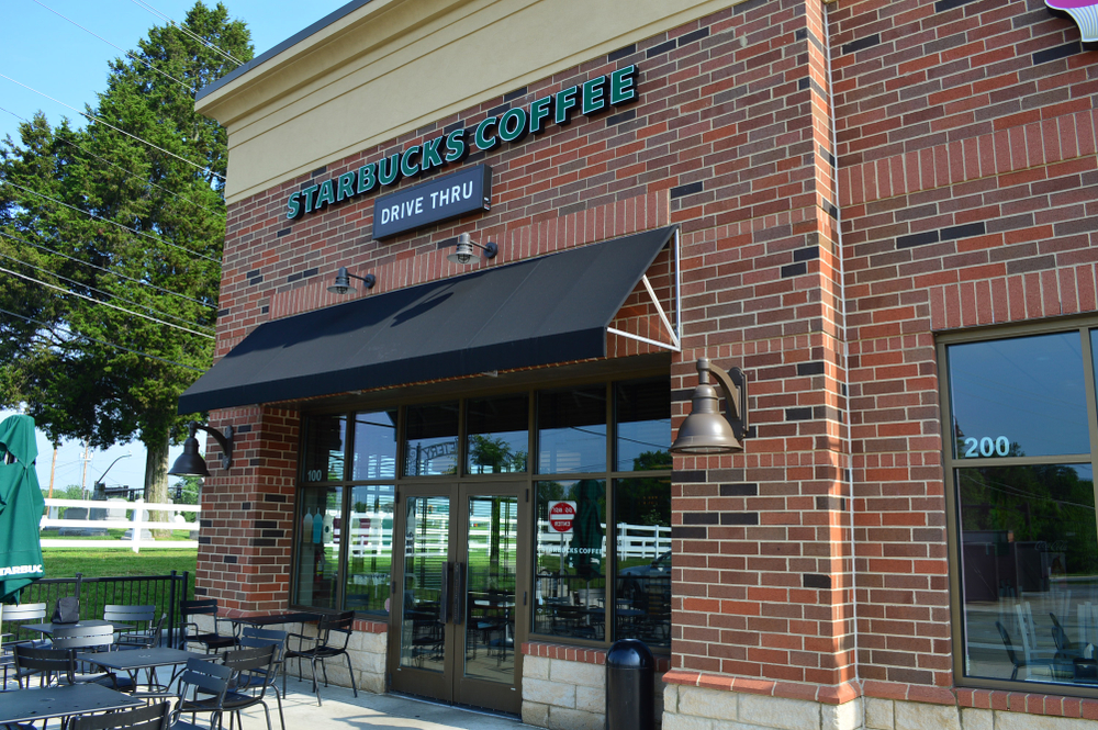 Retail Commercial Building | Single-Tenant Retail Propert Retail commercial building with brick exterior, storefront windows, outdoor seating, and drive-through access.