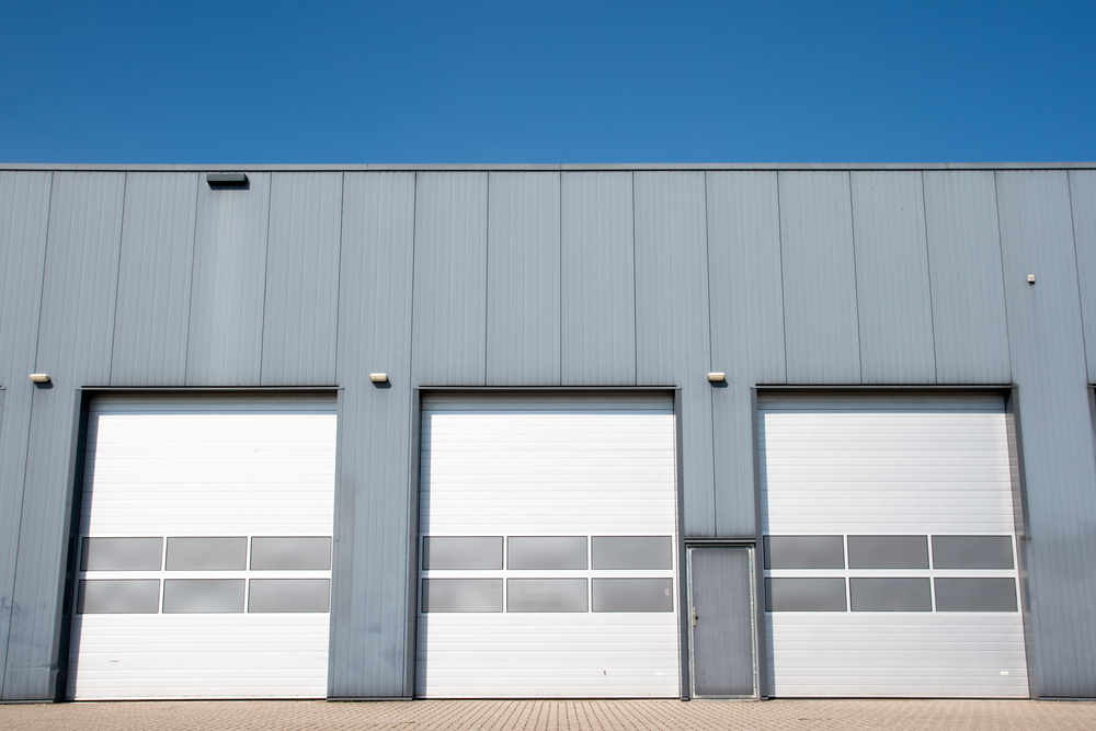 Industrial warehouse exterior with loading doors inspected during a commercial property inspection in Utah.