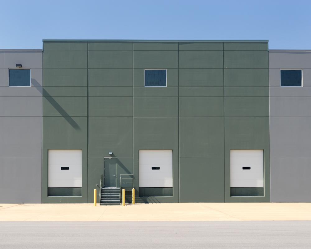 Modern warehouse building with three loading docks inspected as part of a commercial property inspection in Utah.